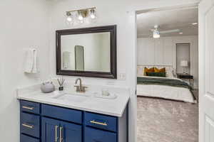 Bathroom with ceiling fan, vanity, and a textured ceiling