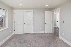 Unfurnished bedroom featuring carpet and a closet