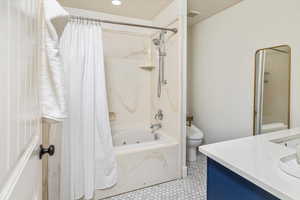 Full bathroom featuring shower / bath combo, vanity, and toilet