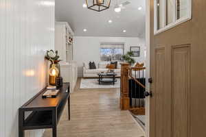 Interior space with ceiling fan with notable chandelier and light wood-type flooring