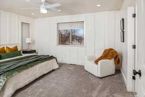 Bedroom with ceiling fan, carpet floors, and a textured ceiling