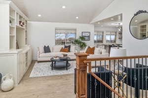 Living room featuring light wood-type flooring and lofted ceiling