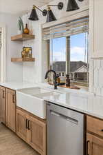 Kitchen with dishwasher, light hardwood / wood-style floors, and sink