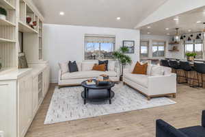 Living room with lofted ceiling and light wood-type flooring