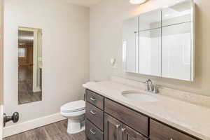 Bathroom with hardwood / wood-style floors, vanity, and toilet