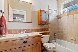 Full bathroom featuring vanity, toilet, and tiled shower / bath