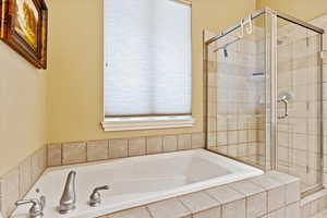 Bathroom featuring shower with separate bathtub