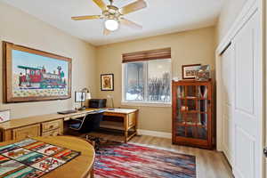 Office area with ceiling fan and light hardwood / wood-style floors