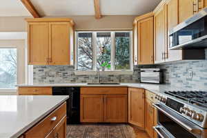 Kitchen with beamed ceiling, decorative backsplash, sink, and stainless steel appliances