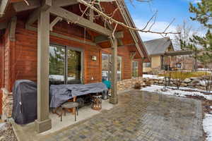 Snow covered patio with a grill