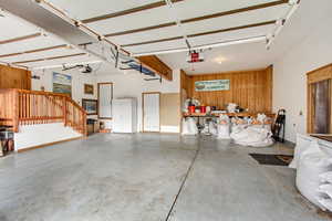 Garage with a garage door opener and wood walls