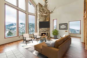 Living room featuring a mountain view, high vaulted ceiling, light wood-type flooring, a fireplace, and a notable chandelier