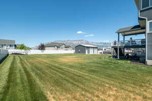 View of yard with a deck with mountain view