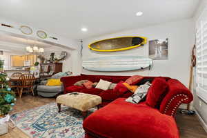 Living room featuring a notable chandelier and dark hardwood / wood-style flooring