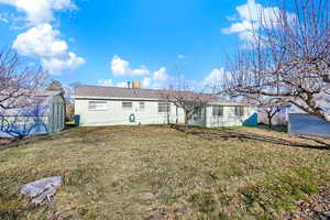 Back of house with lawn and storage sheds 16x16 and 8x7