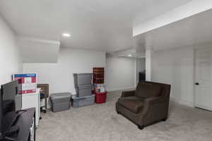 Living area with light colored carpet and a textured ceiling