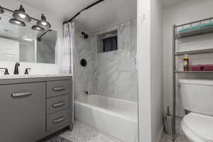 Full bathroom featuring tile patterned floors, vanity, toilet, and shower / bathtub combination with curtain