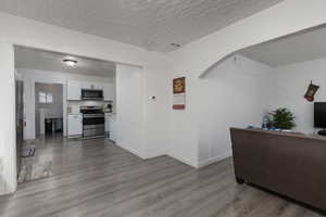 Living room with light hardwood / wood-style flooring and a textured ceiling