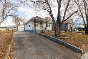 View of front of home featuring a porch, a garage, and an outdoor structure