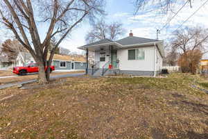 View of front of house with central air condition unit and a front lawn