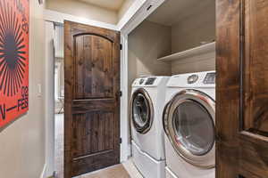 Clothes washing area featuring washer and clothes dryer and light tile patterned floors