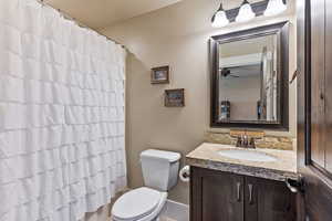 Bathroom with vanity, ceiling fan, and toilet