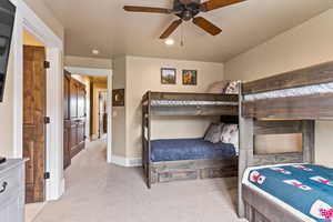 Bedroom with ceiling fan and light carpet