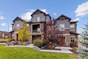 View of front of house featuring a front yard, a balcony, and a patio area