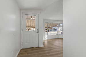 Entryway with vinyl plank floors and lofted ceiling