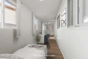 Bedroom featuring vaulted ceiling and vinyl plank flooring