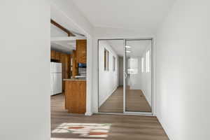 Hall with vinyl plank flooring and lofted ceiling