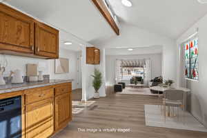 Kitchen featuring dishwasher, vaulted ceiling with beam, and light vinyl plank flooring