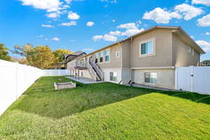 Rear view of property featuring a patio area, a yard, and a wooden deck