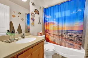 Full bathroom with shower / bath combo, vanity, toilet, and tile patterned floors