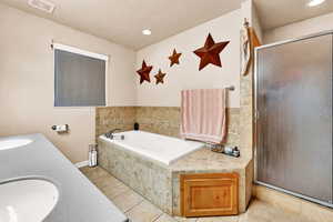 Bathroom featuring tile patterned floors, vanity, a textured ceiling, and independent shower and bath