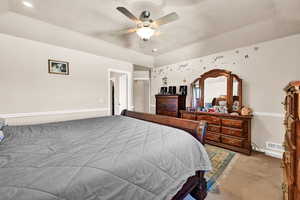 Bedroom with carpet flooring, ceiling fan, and a textured ceiling