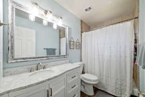 Bathroom featuring vanity, toilet, and walk in shower