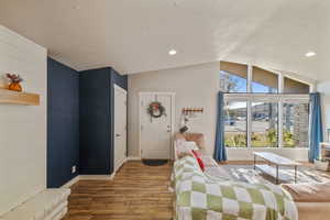 Living room featuring a textured ceiling, vaulted ceiling, and dark wood-type flooring