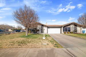 Ranch-style home featuring a front yard and a garage