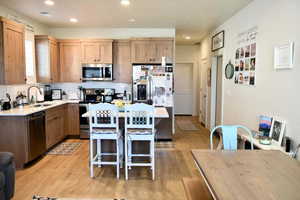 Kitchen featuring a center island, sink, a breakfast bar area, light hardwood / wood-style floors, and stainless steel appliances