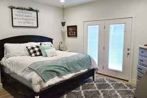 Bedroom with access to outside and wood-type flooring