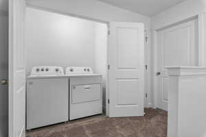 Clothes washing area with carpet floors and washing machine and clothes dryer