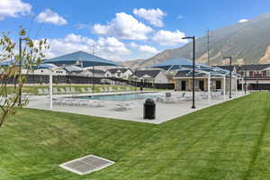 View of swimming pool featuring a lawn, a mountain view, and a patio