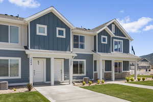 View of front of house with central AC unit and a front lawn