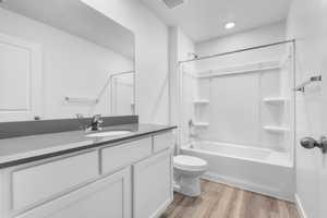 Full bathroom featuring shower / washtub combination, vanity, wood-type flooring, and toilet