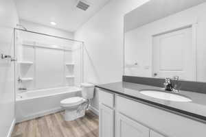 Full bathroom featuring wood-type flooring, a textured ceiling, toilet, vanity, and bathtub / shower combination