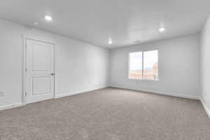 Carpeted spare room featuring a textured ceiling