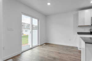 Unfurnished dining area with a healthy amount of sunlight and light wood-type flooring