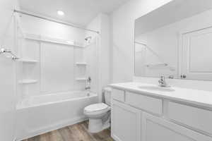 Full bathroom with LVP floors, vanity, toilet, and washtub / shower combination