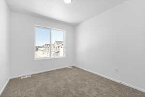 Empty room with carpet and a textured ceiling